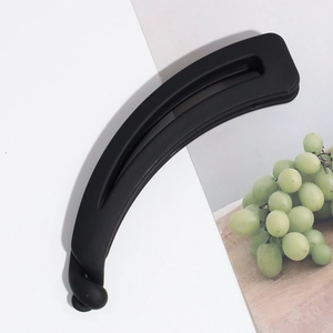 Détail d'une pince banane noire mate avec design ondulé et fermoir à verrouillage