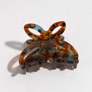 Macro detail of the butterfly hair claw showing tortoiseshell and blue acetate texture