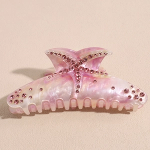Détail macro de la pince à cheveux étoile de mer rose nacré avec strass étincelants