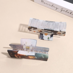 Halloween square hair claw clips set with pumpkin and ghost prints on a textured surface