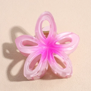 Gros plan détaillé d'une pince à cheveux fleur rose dégradé avec ressort en métal doré