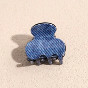 Close-up of hair claw clip with denim blue texture and vintage resin material