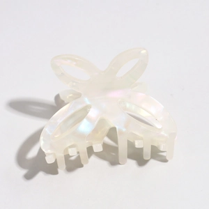 Detailed macro view of pearlescent white butterfly hair claw with hollow wing design