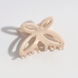 Close-up of a cream butterfly hair claw clip with a hollow resin wing design