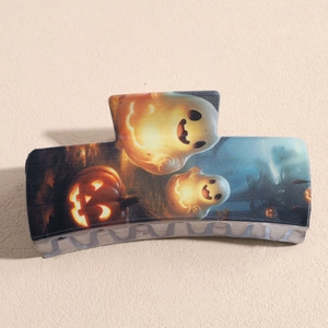 Detail of square hair claw clip featuring festive ghost and pumpkin halloween prints