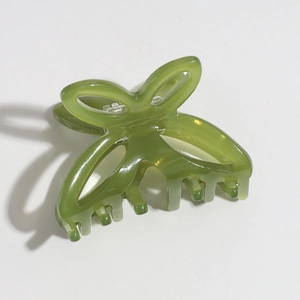 Detail view of small green translucent resin butterfly hair claw clip for elegant hairstyles