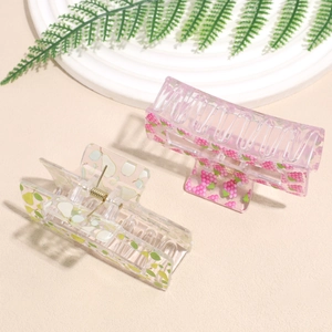 Pastel pink and clear acrylic square hair claws with berry and pear prints on a tray