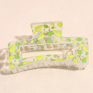 Macro detail of large rectangular hair claw clip with fresh green pear pattern and spring