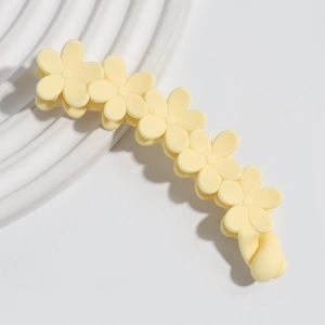 Détail d'une pince à cheveux mate crème avec motif floral élégant sur support blanc