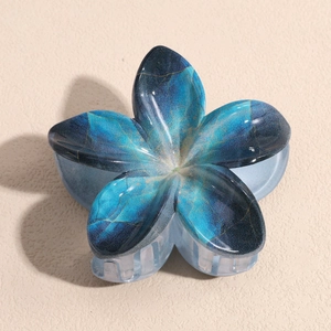 Détail de la pince à cheveux en forme de lys marbré bleu avec de fines lignes dorées