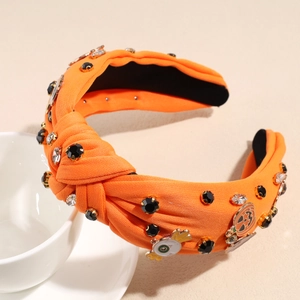 Détail de serre-tête orange avec strass et charms d'Halloween citrouille et fantôme