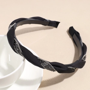 Détail du serre-tête torsadé en satin noir avec strass et dents antidérapantes