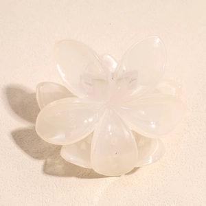 Detail view of the inner spring mechanism and model marking on a cream flower hair claw