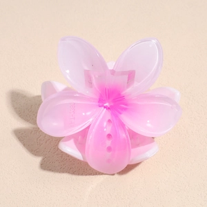 Detailed close-up of a pink gradient cherry blossom hair claw with textured resin petals