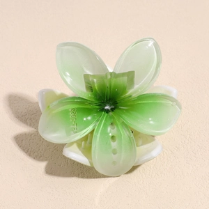 Detail view of flower hair claw clip with green white gradient and resin texture