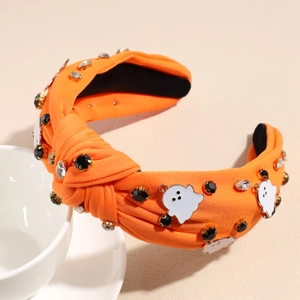Détail du serre-tête orange avec des breloques fantômes blancs et des strass brillants
