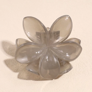 Detail of gray translucent flower hair claw clip with metal spring and matte finish