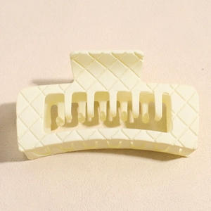 Detail view of large cream square hair claw clip with quilted texture and matte finish