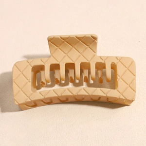 Detailed macro view of the large matte square hair claw clip with woven texture in beige