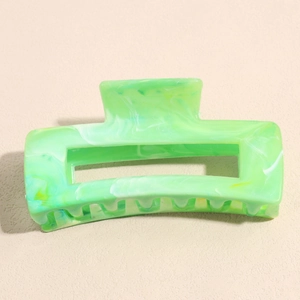 Detail of large marble green hair claw clip showing glossy finish and non-slip design