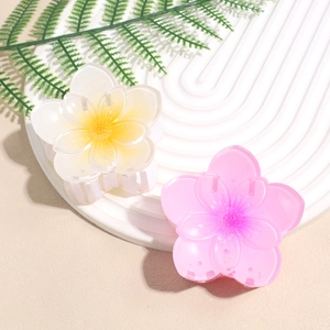 Floral hair claw clips in gradient yellow and purple on a white textured display plate