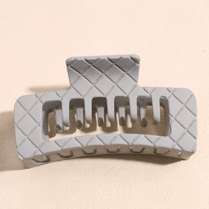 Detail of grey square hair claw clip featuring classic woven lattice texture and matte finish
