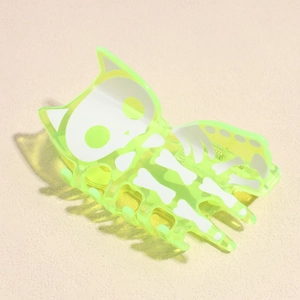 Détail de la pince à cheveux chat squelette vert néon avec motif d'os pour Halloween
