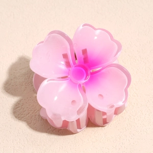 Vue détaillée d'une pince à cheveux en forme de fleur rose aux pétales translucides