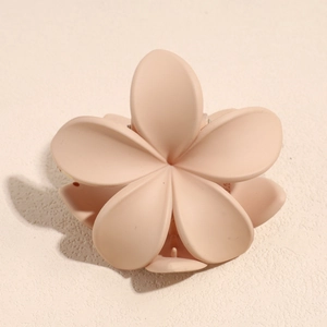 Detailed top view of a matte beige flower hair claw clip with a five-petal resin design