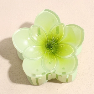 Detailed view of light green translucent gradient flower hair claw clip with steady teeth