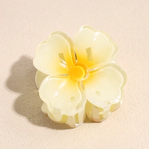 Vue détaillée d'une pince à cheveux en forme de fleur crème mate avec texture en résine
