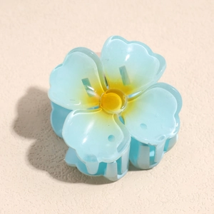 Détail de la pince à cheveux en forme de fleur bleu clair translucide avec dégradé jaune