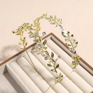 Serre-tête élégant en métal doré avec feuilles et strass dans un coffret à bijoux beige