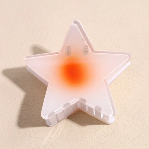 Pince à cheveux étoile avec finition givrée et dégradé orange sur fond texturé
