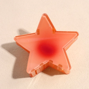 Détail de la pince à cheveux en forme d'étoile orange-rose avec dégradé rouge central