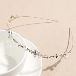Close-up of golden headband featuring enamel butterflies, pearls, and sparkling rhinestones