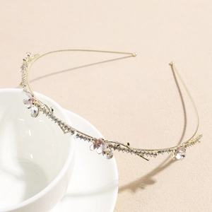 Detail of golden floral headband with enamel cherry blossoms and sparkling rhinestones