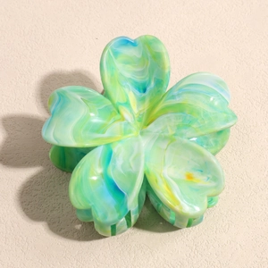 Detail of flower hair claw clip with green and yellow marble texture finish