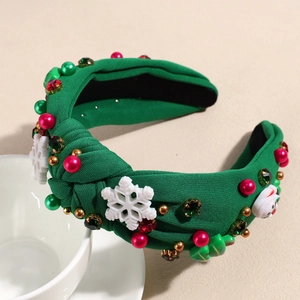 Détail du serre-tête de Noël noué vert avec perles, cristaux et décorations de flocons