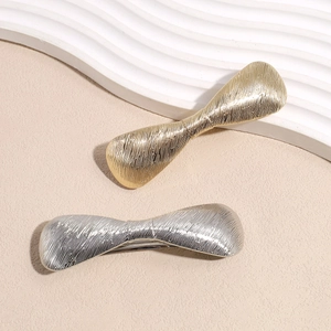 Eleganti fermagli per capelli a fiocco in metallo oro e argento con texture spazzolata