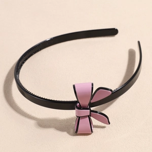 Detail shot of the pink bow headband showing non-slip inner teeth and polished frame