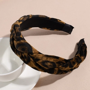 Close-up of leopard print velvet headband with twisted braid design and soft texture