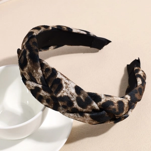Detail view of leopard print plush braided headband resting on white ceramic cup