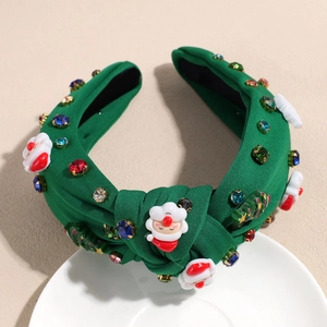 Détail du serre-tête de Noël en tricot vert avec strass et charms de Père Noël