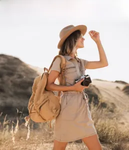 Foto lifestyle di uno zaino in tela kaki e vestito utility coordinato nel deserto sabbioso