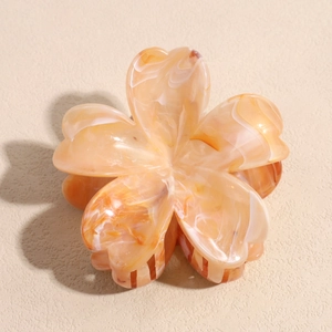 Detailed top view of a marble texture orange flower hair claw clip with acrylic finish