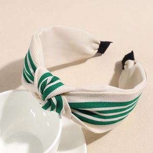 Detail view of a striped knit headband with knot design on a white ceramic cup