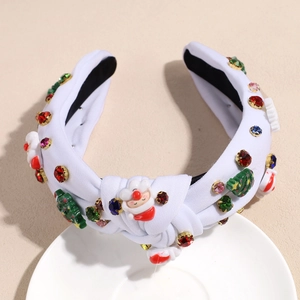 Détail d'un serre-tête de Noël en tricot blanc avec Père Noël et strass colorés