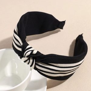 Detail showing classic black and white striped knot headband on a ceramic cup