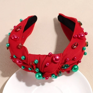 Détail d'un serre-tête noué rouge avec perles de Noël et strass étincelants